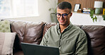 Man, relax and smile with laptop in living room for movie, streaming film or video. Person, home and digital tech for social media, online podcast and search on weekend for internet entertainment