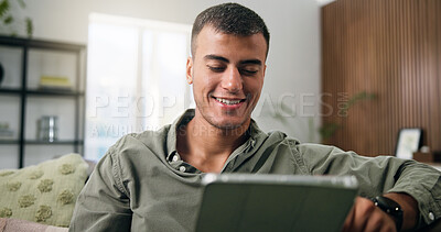 Buy stock photo Man, tablet and reading on sofa for social media, communication or entertainment in home living room. Male person, smile and relax on lounge couch with technology for online streaming and search