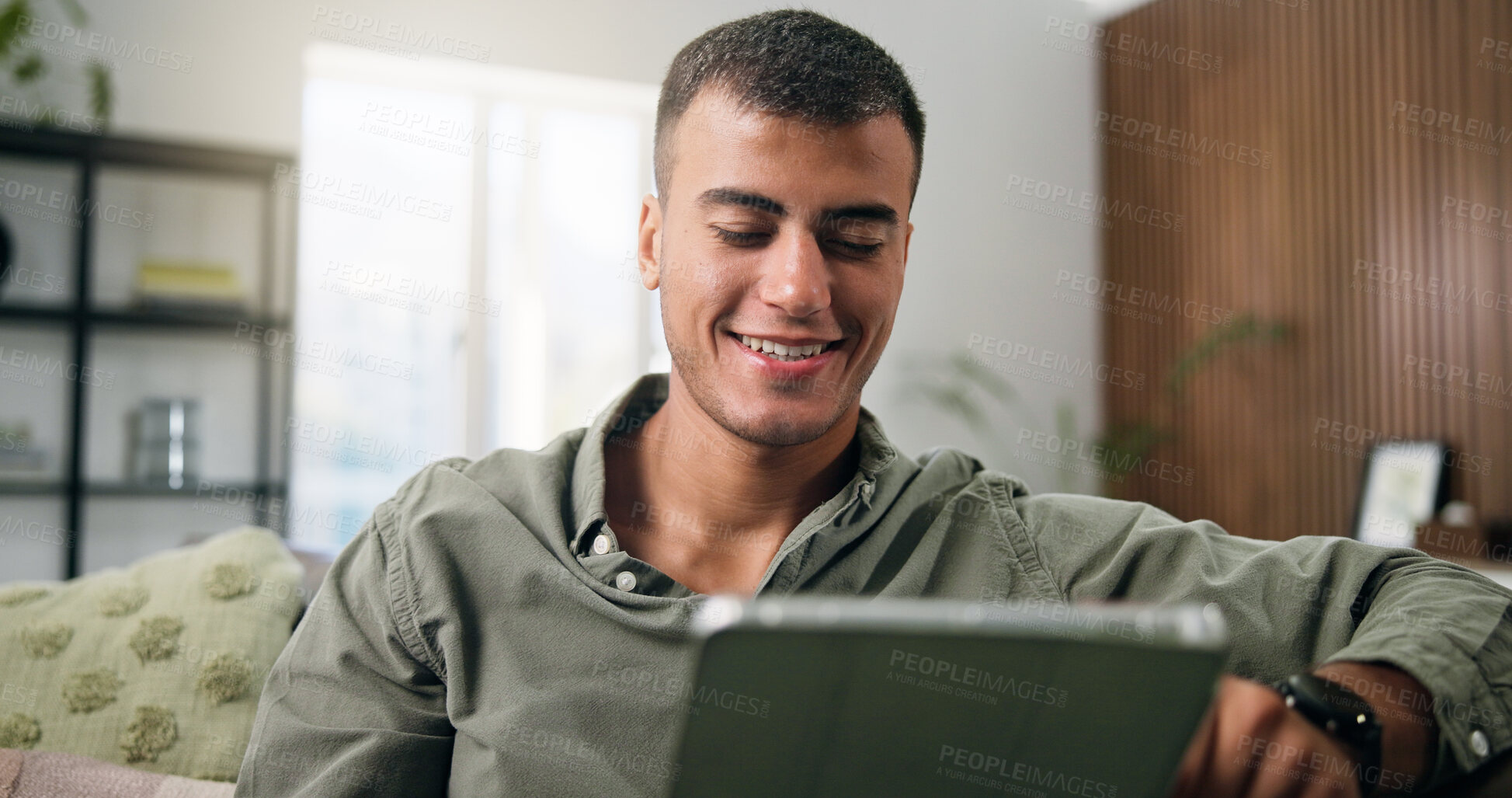 Buy stock photo Man, tablet and reading on sofa for social media, communication or entertainment in home living room. Male person, smile and relax on lounge couch with technology for online streaming and search
