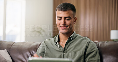 Buy stock photo Man, tablet and relax on sofa for social media, communication or entertainment in home living room. Male person, typing and smile on lounge couch with technology for online streaming and search