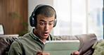 Shock, tablet and man on sofa with headphones for online videos, subscription and watching movies. Home, reaction and person on digital tech for internet, website and streaming drama show on weekend