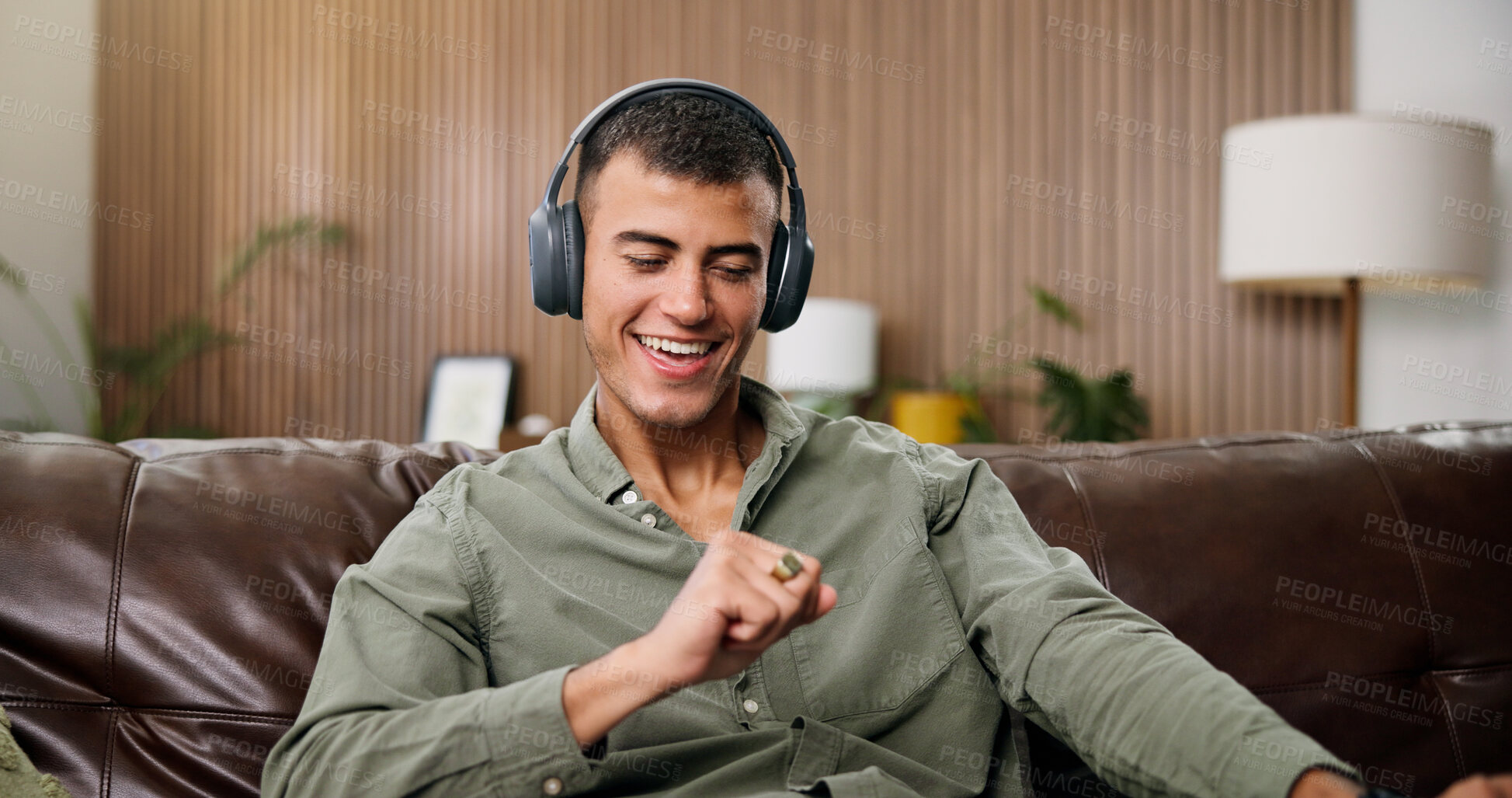 Buy stock photo Man, smile and dance with headphones on sofa for streaming, song and sound in living room at house. Person, smartphone and listen to music with subscription, audio or happy for rhythm at apartment