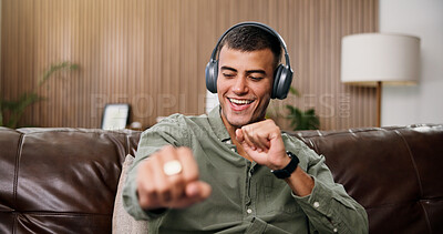 Buy stock photo Man, happy and dance with headphones on sofa for streaming, song and sound in living room at house. Person, smartphone and listen to music with subscription, audio or smile for rhythm at apartment