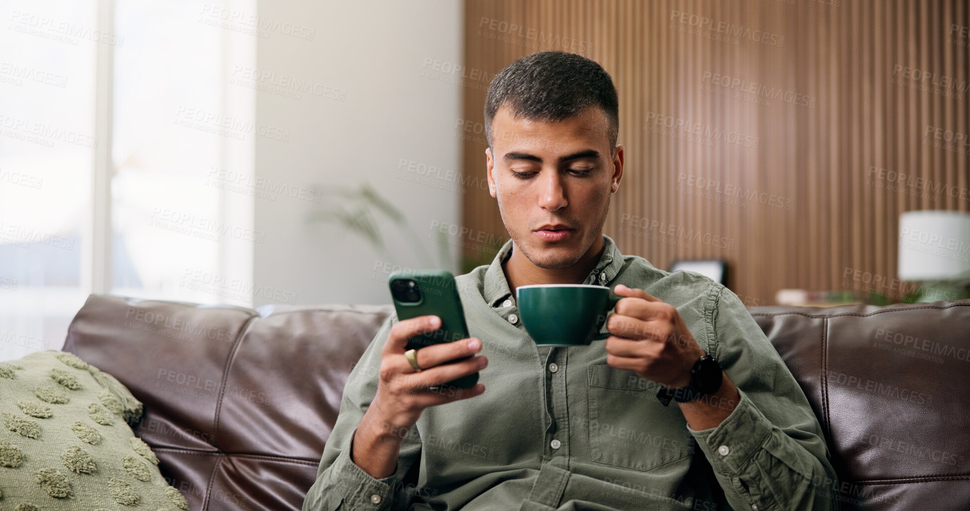 Buy stock photo Coffee, home and man on sofa with phone for social media, online message and chat in living room. Weekend, relax and person on smartphone for internet, connection and text on mobile app with drink