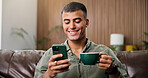 Coffee, happy and man on sofa with phone for social media, online message and chat in home. Weekend, relax and person on smartphone for internet, connection and notification on mobile app with drink