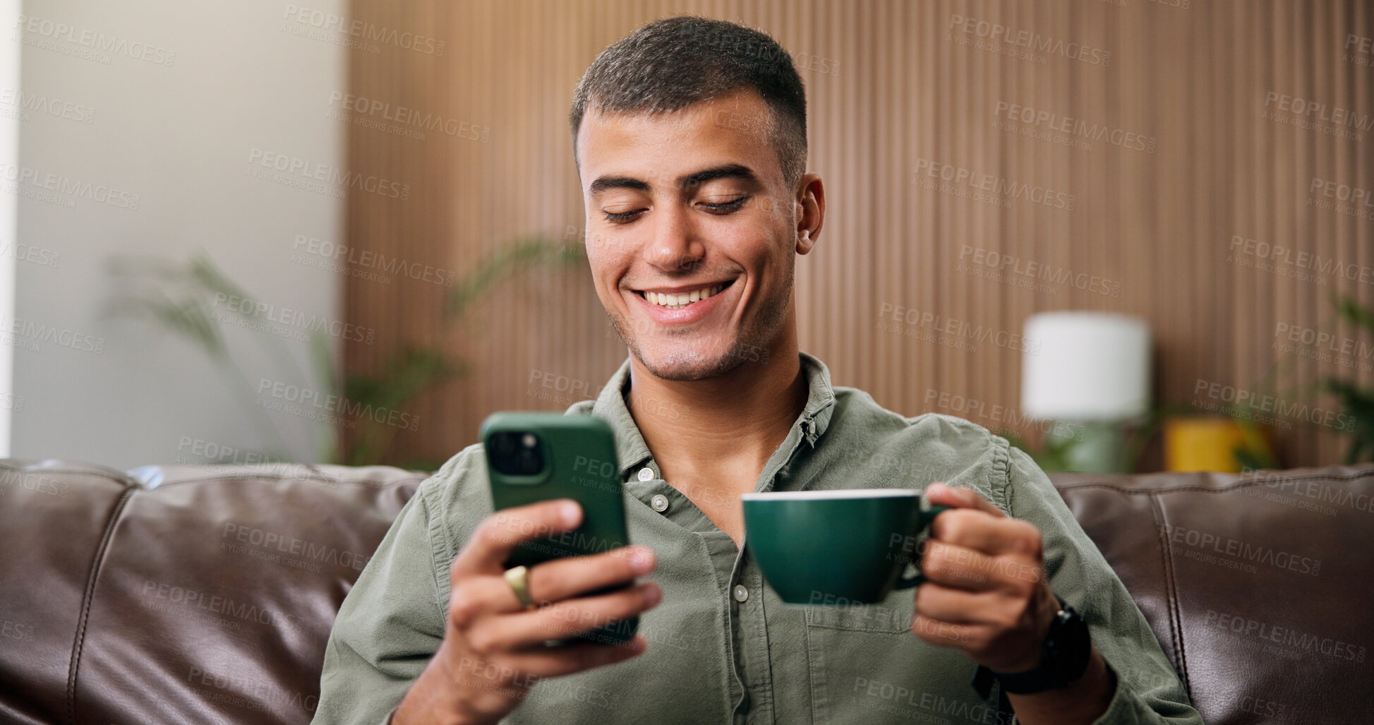 Buy stock photo Coffee, happy and man on sofa with phone for social media, online message and chat in home. Weekend, relax and person on smartphone for internet, connection and notification on mobile app with drink
