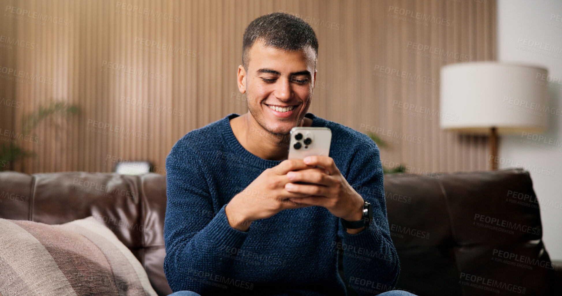 Buy stock photo Typing, happy and man on sofa with phone for social media, online message and chat in home. Weekend, laugh and person on smartphone for internet, connection and reading notification on mobile app