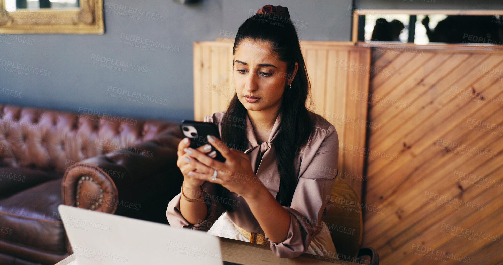 Buy stock photo Laptop, woman and reading phone in cafe for bad review, small business manager and stock mistake. Owner, person and serious with tech in restaurant for customer complaint, app feedback or poor rating