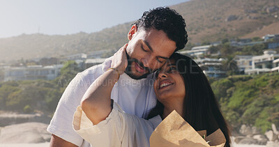 Buy stock photo Smile, couple and love with bouquet at beach for romantic date, celebration and bonding together. Happy, people and embrace with flowers for romance, anniversary getaway and surprise gift at seaside