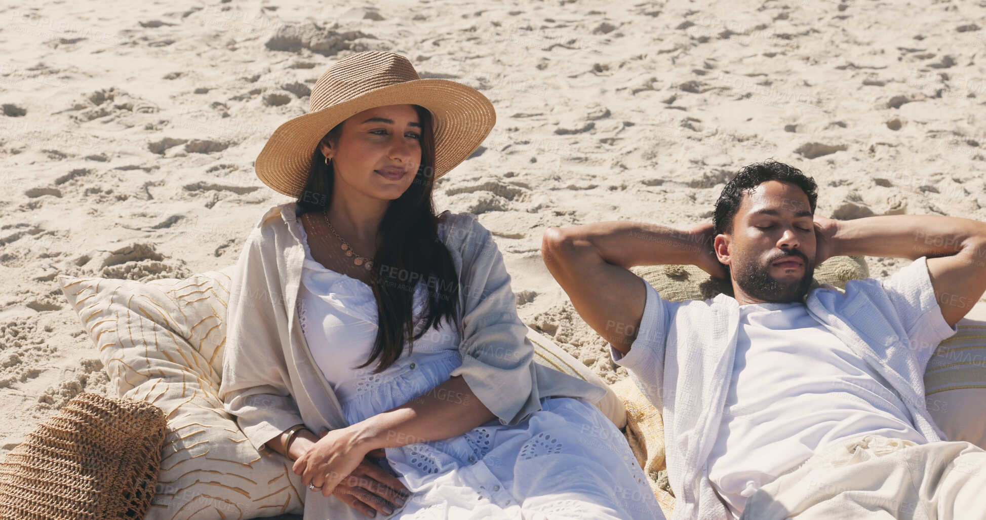 Buy stock photo Couple, relax and picnic at beach on vacation with thinking, rest and perspective with sunhat in summer. Woman, reflection and break with partner, sleeping and daydream with pillow on seaside holiday