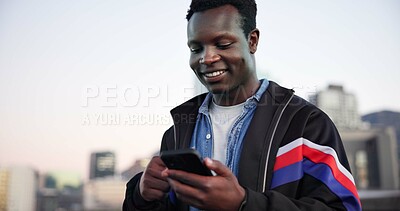 Buy stock photo Black man, phone and texting in city for smile with sky, space and check notification for chat. African person, happy and smartphone in urban town with online dating, gen z style and streetwear