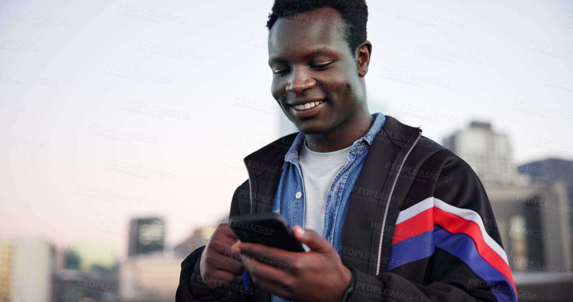 Buy stock photo Black man, phone and texting in city for smile with sky, space and check notification for chat. African person, happy and smartphone in urban town with online dating, gen z style and streetwear