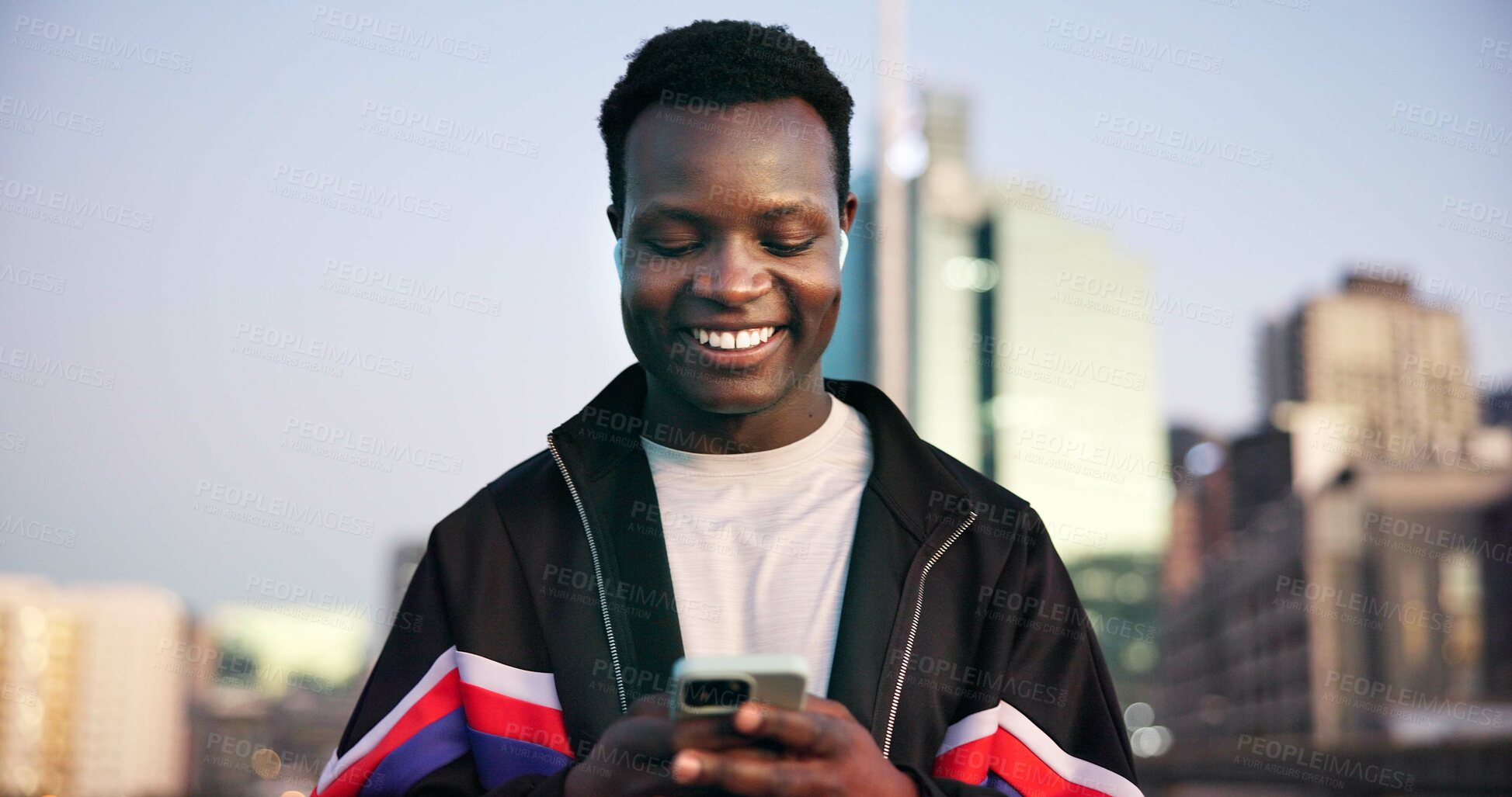 Buy stock photo Black man, fitness and phone with earphones in city for break, streaming service and audio with smile. African person, runner and smartphone on music app, subscription or rest for exercise in town