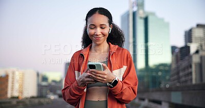 Buy stock photo Happy woman, fitness and phone with earphones in town on break, streaming and space on bridge. Gen z girl, runner and listen to music with app, smile or rest with smartphone for exercise in city