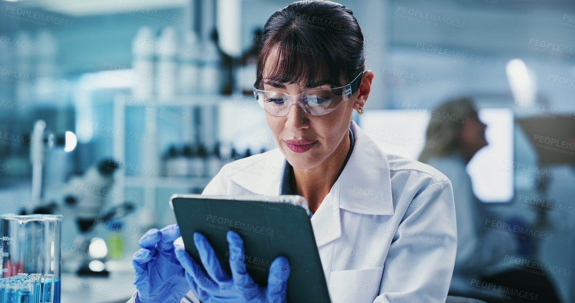 Buy stock photo Scientist, woman and reading in lab with tablet, PPE or email experiment results for medical research. Update, mature person and browsing in clinic with tech, science website and healthcare study.