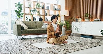 Buy stock photo Calm, man and meditation with prayer in lounge, mindfulness and zen with spiritual awareness in home. Person, wellness and self care for mental health on break, relax or healing with yoga and balance