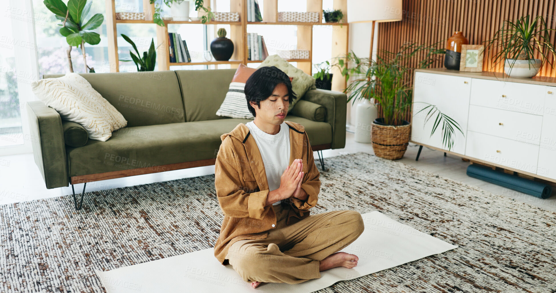 Buy stock photo Man, relax and meditation with prayer in lounge, mindfulness or zen with spiritual awareness in home. Calm, person and self care for mental health on break, wellness and healing with yoga and balance