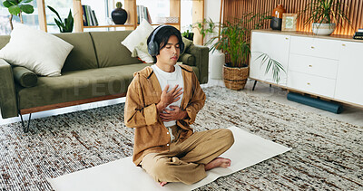 Buy stock photo Man, relax and meditation with headphones in lounge, mindfulness and spiritual awareness with audio. Calm, person and self care for mental health on break, listen and inner peace with sound in house
