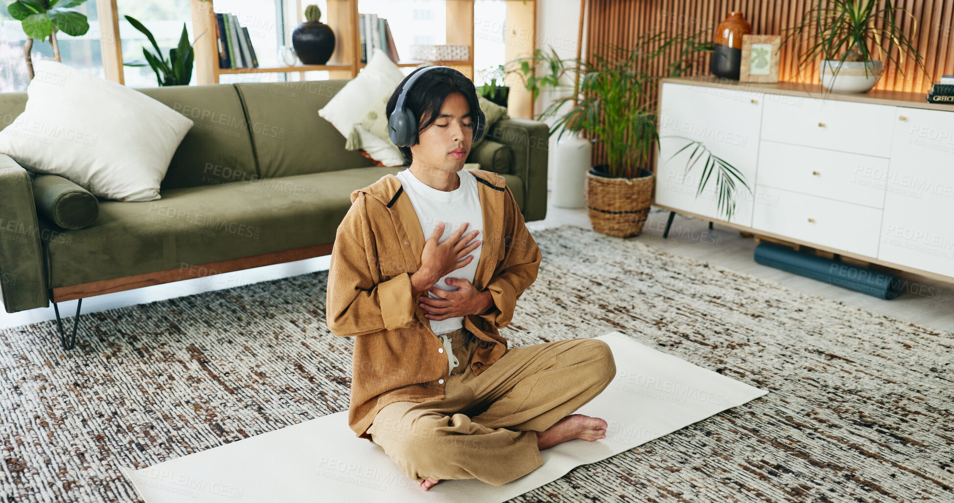 Buy stock photo Man, relax and meditation with headphones in lounge, mindfulness and spiritual awareness with audio. Calm, person and self care for mental health on break, listen and inner peace with sound in house