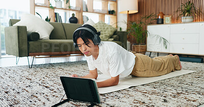 Buy stock photo Fitness, headphones and tablet with Asian man in home living room for exercise or training routine. Health, plank and video streaming with person on floor in apartment for online course or tutorial