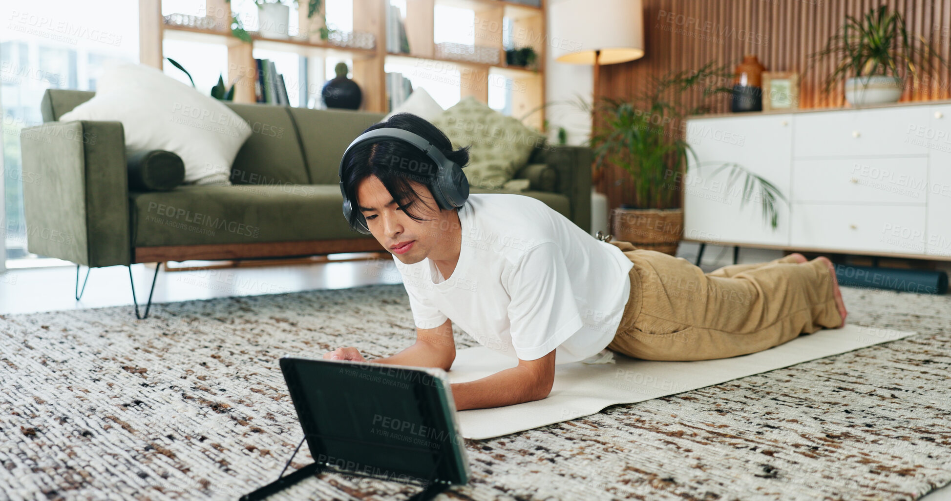 Buy stock photo Fitness, headphones and tablet with Asian man in home living room for exercise or training routine. Health, plank and video streaming with person on floor in apartment for online course or tutorial