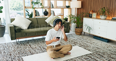 Buy stock photo Yoga mat, music or man with phone in home for meditation song, sound and relax for calm. Mobile, headphones or Asian person on floor for fitness podcast, wellness audio or streaming with zen playlist