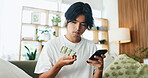 Phone, pills and man in home for research, healthcare information or reading label for dose. Mobile, drugs and Asian person in house for medical prescription, medicine benefits or side effects