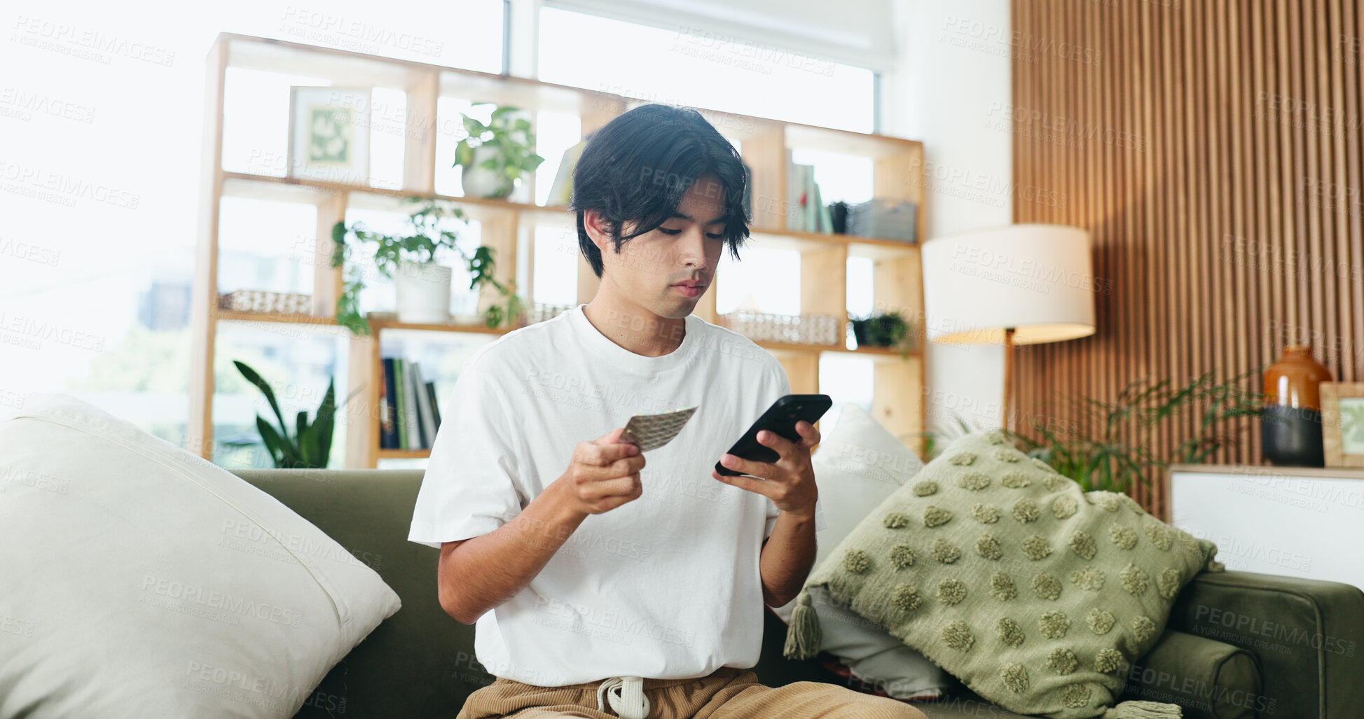 Buy stock photo Man, phone and pills on couch with search for side effects, ingredients or allergies on web at home. Person, smartphone and check medicine on mobile app, supplements and drugs for wellness in house