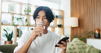 Man, phone and drinking water on sofa with thinking, relax and break with texting in living room. Person, smartphone and glass with mobile app, hydration and perspective with web chat at apartment
