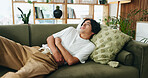 Couch, discomfort and man with stomach pain in home, indigestion or food poisoning for gastro cramps. Sore tummy, bowel emergency or asian person with ibs condition for ache, constipation or diarrhea