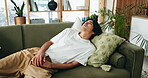 Thinking, sad and asian man relax on couch, introspection and self reflection for emotional processing. Rest, home and person with confirmation bias for experience memory, regret and remember mistake