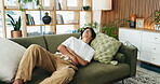 Sofa, discomfort and man with stomach pain in home, indigestion or food poisoning for gastro cramps. Sore tummy, bowel emergency or asian person with ibs condition for ache, constipation or diarrhea
