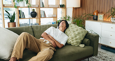 Buy stock photo Sofa, discomfort and man with stomach pain in home, indigestion or food poisoning for gastro cramps. Sore tummy, bowel emergency or asian person with ibs condition for ache, constipation or diarrhea
