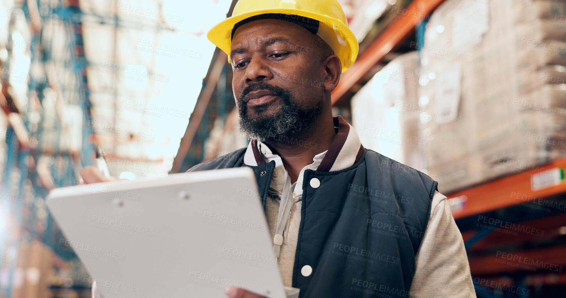 Buy stock photo Logistics, supplier and man with clipboard in warehouse, writing or quality control for distribution. Factory, low angle and black person with checklist for supply chain, mature supervisor and export