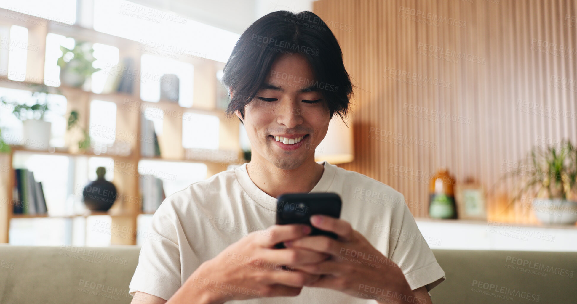 Buy stock photo Texting, smile or Asian man on sofa with phone, online chat or communication on dating site. Happy, conversation or person in house with tech, digital app or connection on matchmaking platform.
