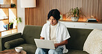 Man, typing and remote work in house with laptop, digital marketing website or plan for campaign. Freelancer, person and research on sofa with computer, creativity or online branding for advertising.