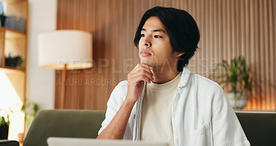 Buy stock photo Laptop, learning and thinking with Asian man on sofa in home living room for online education. Computer, planning and study review with college or university student in apartment for research ideas