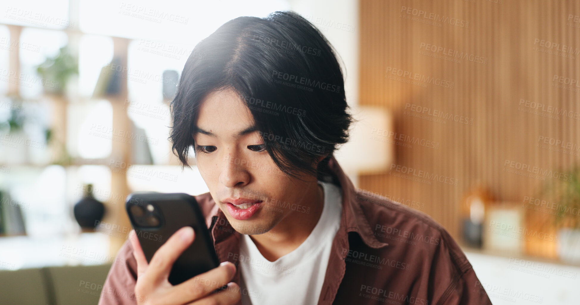 Buy stock photo Smartphone, reading and Asian man in home for blog on social media, update profile and connection. Mobile, person and check app for notification, online comment or post on internet in living room