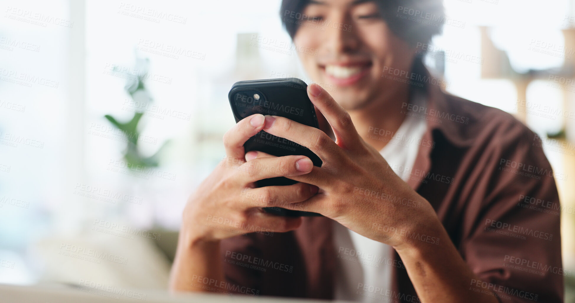 Buy stock photo Texting, happy or Asian man in home with phone, online chat or communication on dating site. Smile, flare or male person in house with tech, digital app or connection on matchmaking platform.
