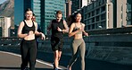 Happy people, fitness or running with friends in city street for cardio workout or outdoor exercise. Active, group or runners with smile on road for physical activity, race or training in urban town