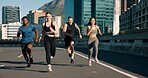 Happy people, fitness or running with friends in road for cardio workout or outdoor exercise. Active, group or runners with smile on city street for physical activity, race or training in urban town
