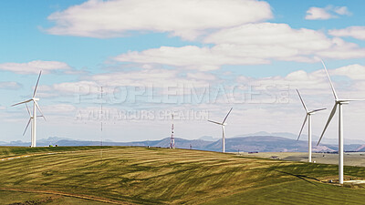 Buy stock photo Blue sky, sustainable and wind turbine outdoor by grass for renewable energy, nature or eco friendly. Field, clouds and windmill for natural resource with economic development in countryside.