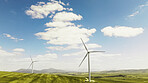 Clouds, nature and wind turbine outdoor by grass for renewable energy, sustainable or eco friendly. Field, blue sky and windmill for natural resource with economic development in countryside.