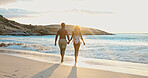 Couple, holding hands and love on beach holiday, sunrise and together on summer adventure and space. Back, people and affection for partner in nature, flare and outdoor for anniversary or vacation