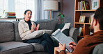 Woman, consulting or talking with therapist for counseling, rehabilitation or therapy session on sofa. Female person, client or discussion with counselor or psychologist for helpful advice in office