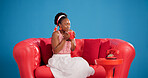Aroma, coffee and studio with black woman on sofa for me time chilling, relax or satisfaction. Break, cup and scent with happy African person drinking beverage on blue background for wellness
