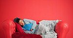 Studio, woman and stomach ache on sofa, pain or period cramps on red background with mockup space. Sore abdomen, constipation and person with indigestion, sick or endometriosis with menstrual cycle