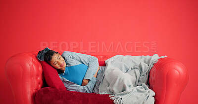 Buy stock photo Studio, woman and stomach ache on sofa, pain or period cramps on red background with mockup space. Sore abdomen, constipation and person with indigestion, sick or endometriosis with menstrual cycle