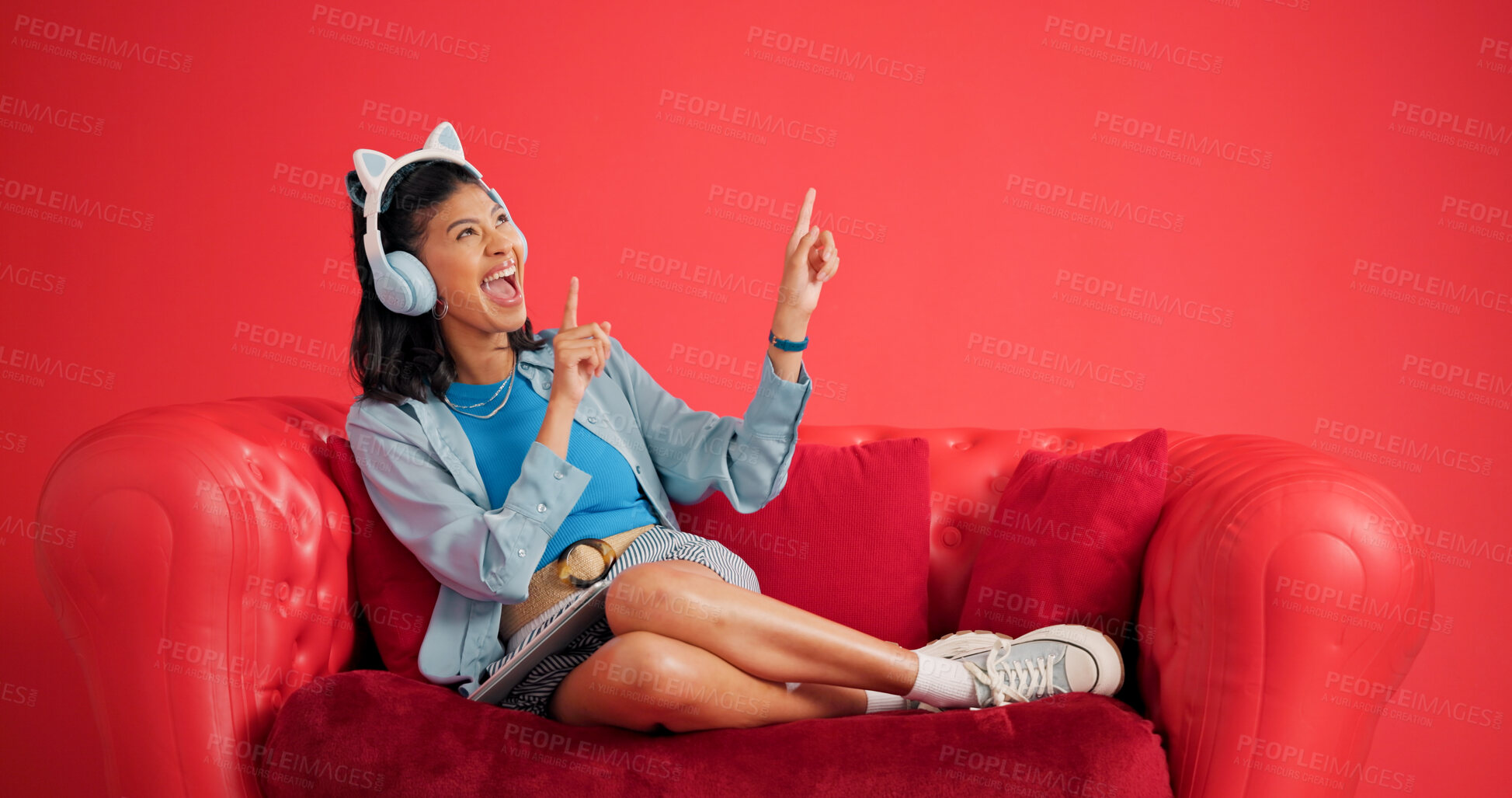 Buy stock photo Woman, couch and headphones in studio with dance, tablet and listening to popular music playlist. Happy, person rhythm and audio tech with sofa, online radio and streaming song on red background.