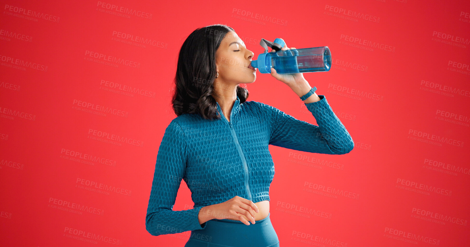 Buy stock photo Woman, drinking water and break for fitness in studio, hydration or mockup space on red background. Girl, bottle and rest with liquid for detox, gut health and electrolytes for wellness with exercise